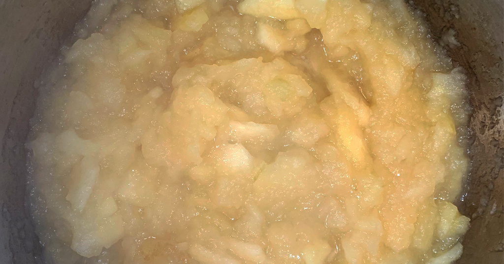 Applesauce cooking in a stainless steel pot