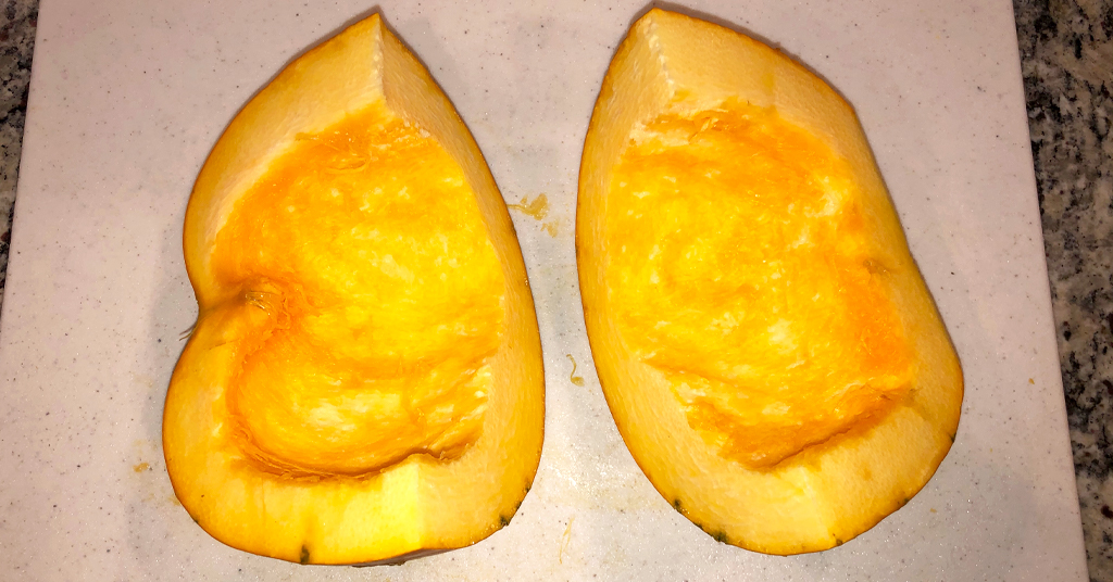 Two halves of a sugar pumpkin with seeds removed