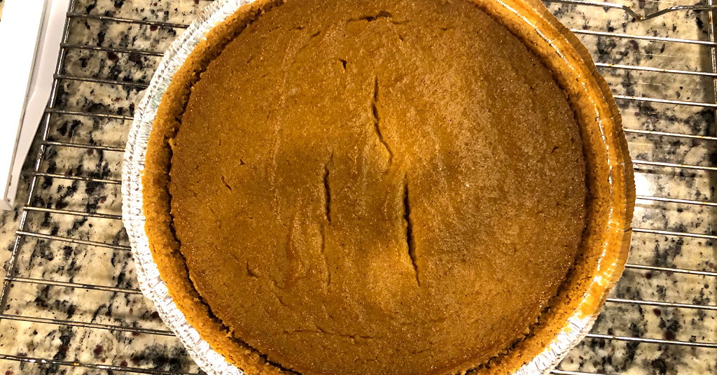 Pumpkin Pie made with a graham cracker crust sitting on a cooling rack