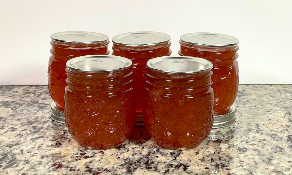 Five Ball mason jars with apple jelly from the Ball water bath canning apple jelly recipe.