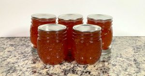 Five Ball mason jars with apple jelly from the Ball water bath canning apple jelly recipe.