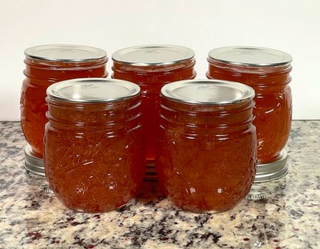 Five Ball mason jars with apple jelly from the Ball water bath canning apple jelly recipe.