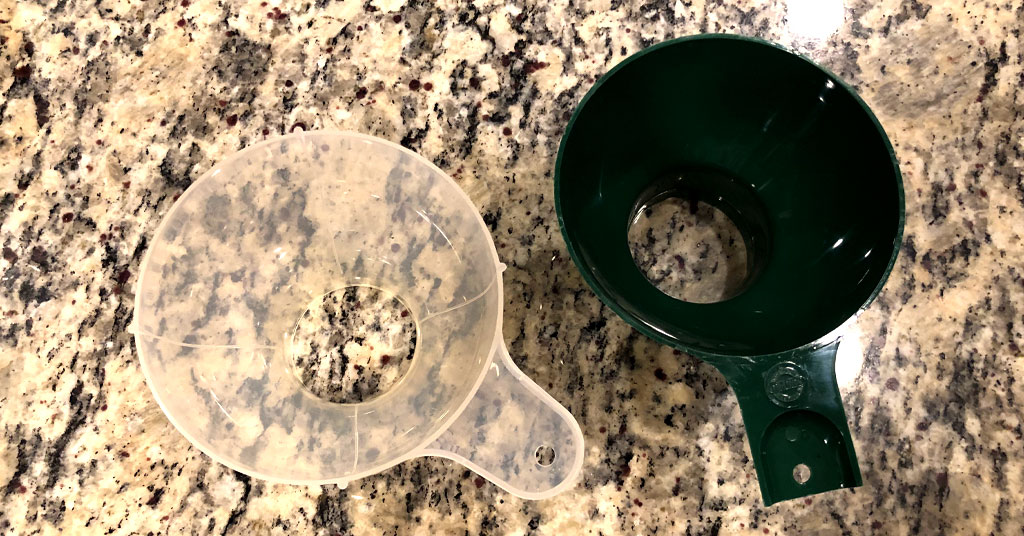 Clear and green funnels used to fill canning jars