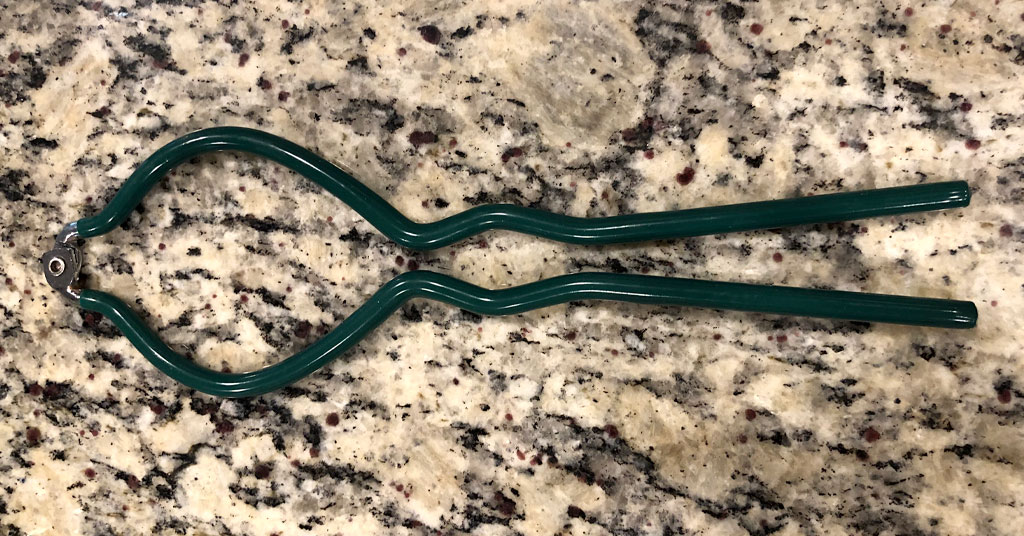 Green silicone jar wrench used to hold hot canning jars