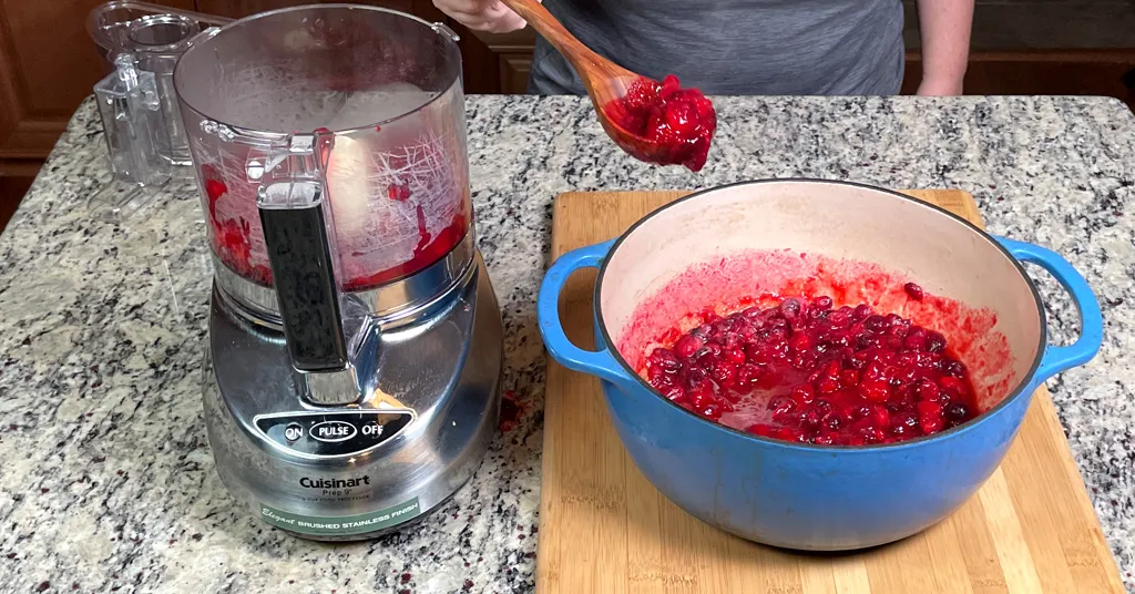 Hot cranberries being ladled into a Cuisinart Stainless Steel Food Processor to make Cranberry Jelly.