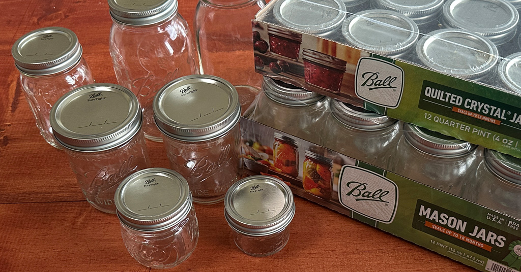 Different sized Ball mason jars and two boxes of mason jars.