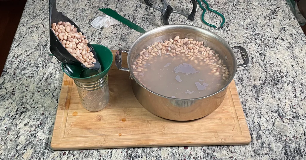 Pinto Beans being ladled into a jar for Pressure Canning.