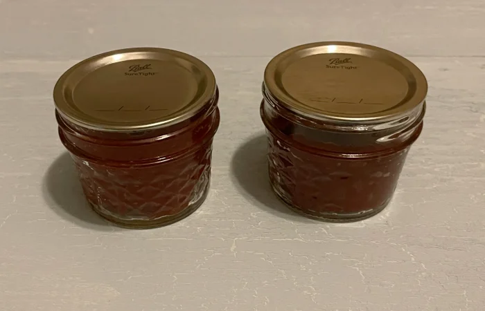 Two mason jars of Roasted Tomato Paste that has been Water Bath Canned.
