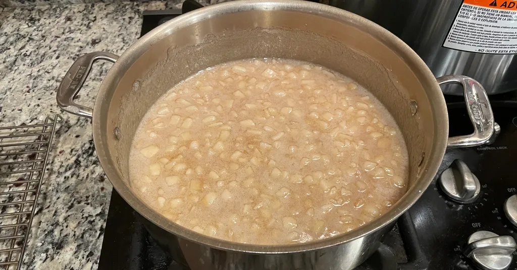 Pear Jam in a stainless steel pot being boiled on a stove.