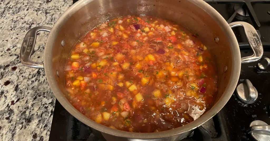 Stainless steel pot full of summer salsa being heated for water bath canning.