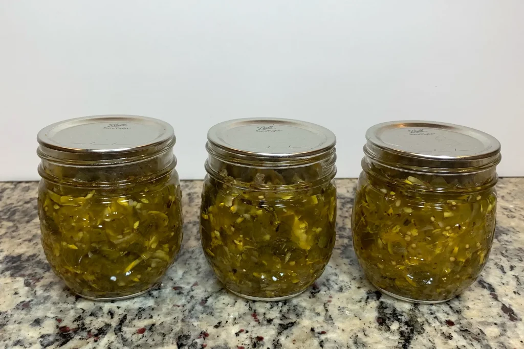 Three mason jars of zucchini relish that has been water bath canned