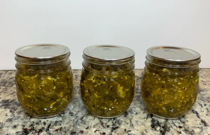 Three mason jars of zucchini relish that has been water bath canned