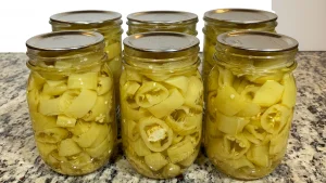 Six Ball mason jars filled with water bath canned pickled banana peppers