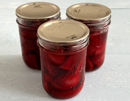 Three mason jars of sliced beets that have been pressure canned for presering.