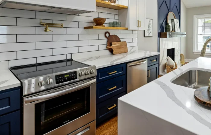 Glass topped stove in a navy blue and white kitchen