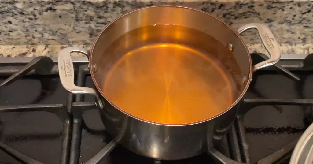 Light syrup in a stainless steel pot.