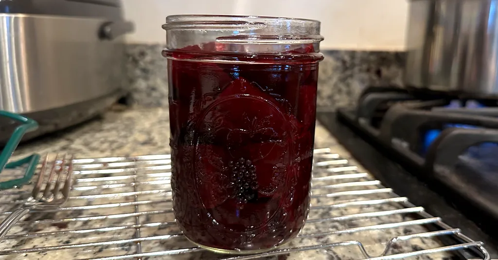 Mason jar of sliced beets that is being hot-packed before pressure canning.
