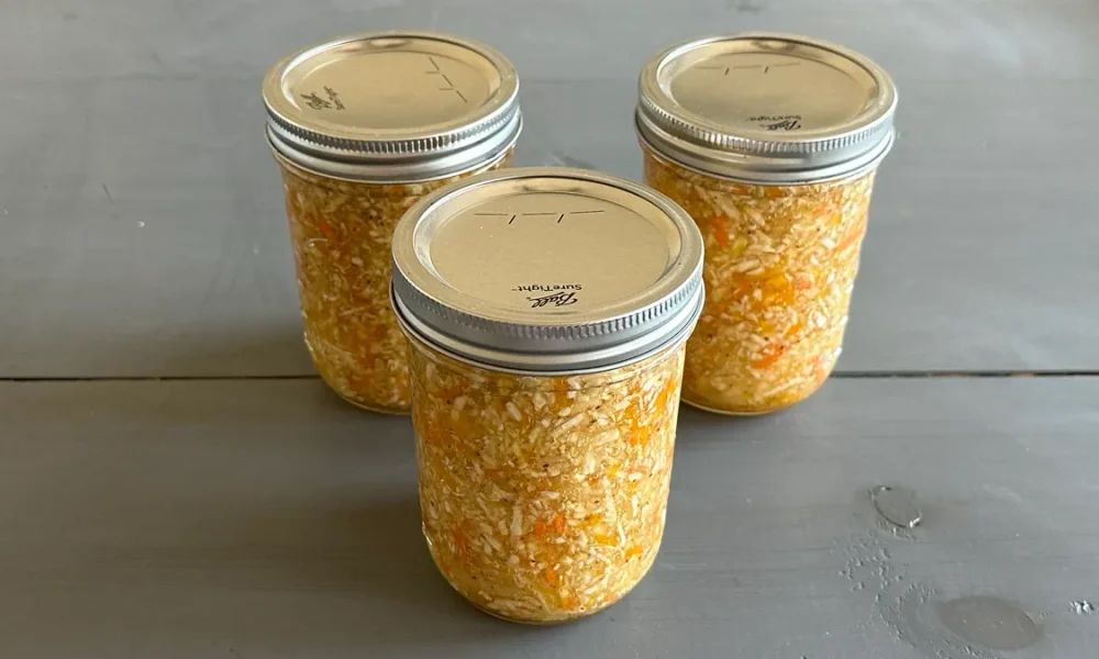 Three mason jars of coleslaw that have been water bath canned.