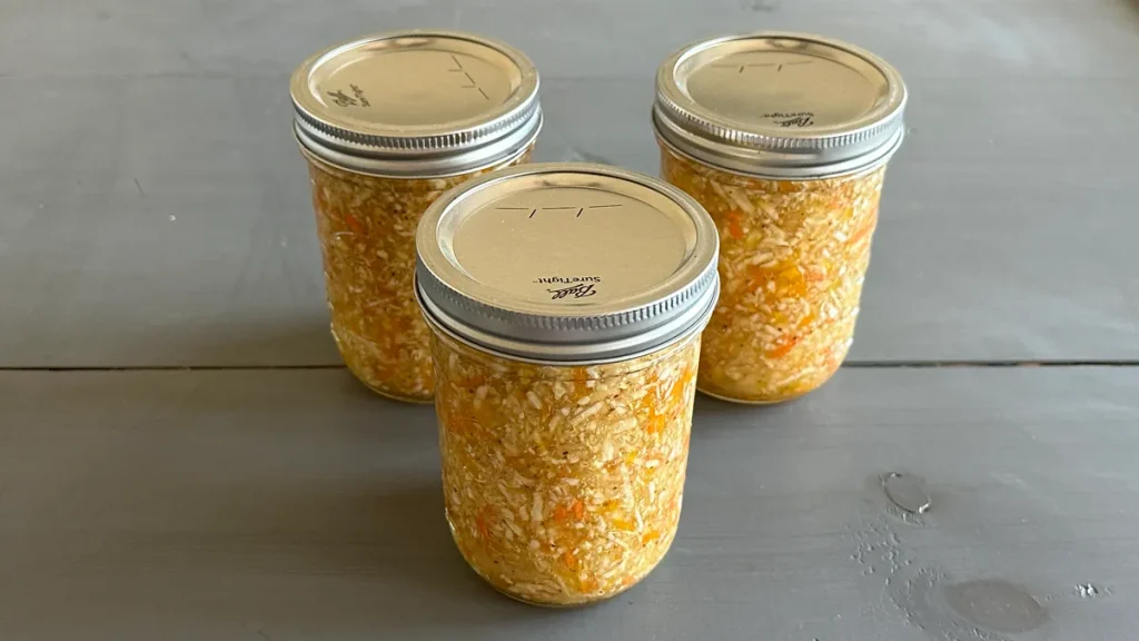 Three mason jars of coleslaw that have been water bath canned.