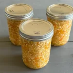 Three mason jars of coleslaw that have been water bath canned.