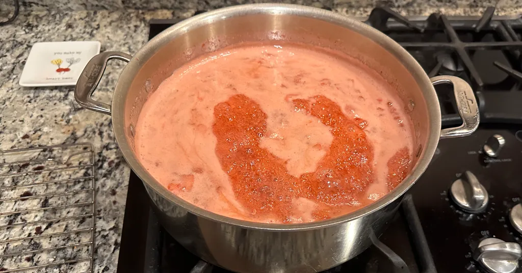 Strawberry Jam being boiled in a stainless steel pot before being canned.
