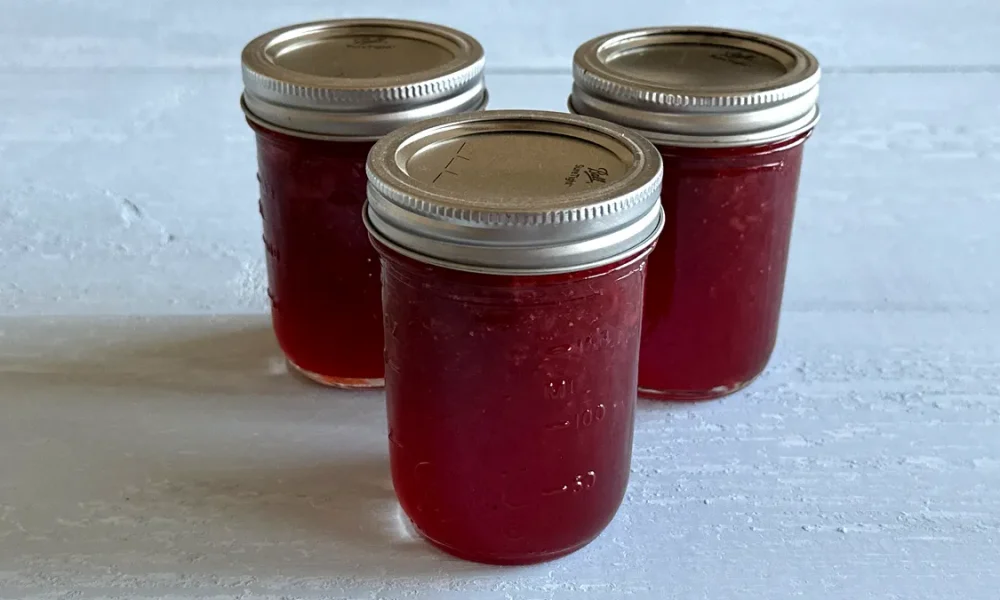Three mason jars of strawberry jam.