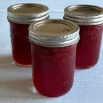 Three mason jars of strawberry jam.