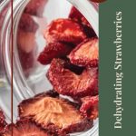 Pinterest Pin for Dehydrating Strawberries Tips and Tricks. Image of a dehydrated strawberries spilling out of a glass jar.