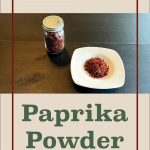 Pinterest Pin for Dehydrating Paprika Powder. Image of dehydrated paprika powder in a small spice jar and sitting on a white plate on a dark surface.