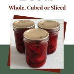 Pinterest Pin for How To Can Beets Whole, Cubed or Sliced. Image of three mason jars of pressure canned beets sitting on a painted surface.