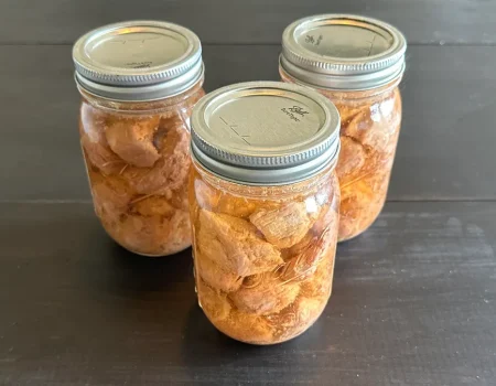 Three mason jars of pressure canned pork tenderloin in broth.