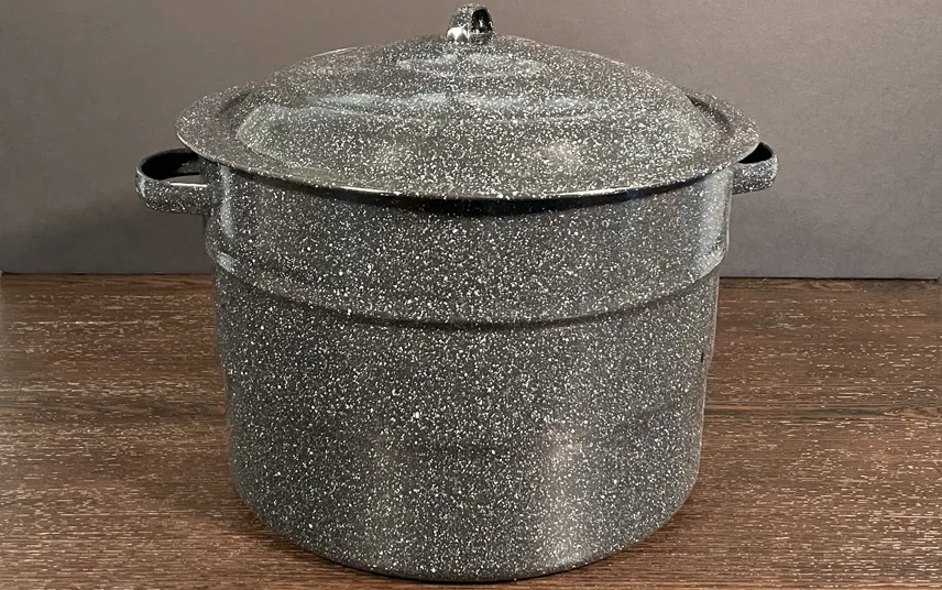 Black Enameled Water Bath Canner sitting on wooden table.