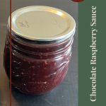 Pinterest Pin for Chocolate Raspberry Sauce Tips and Tricks. Image of a mason jar of chocolate raspberry sauce sitting on a dark surface.