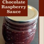 Pinterest Pin for How To Can Chocolate Raspberry Sauce. Image of a mason jar of chocolate raspberry sauce sitting on a dark surface.