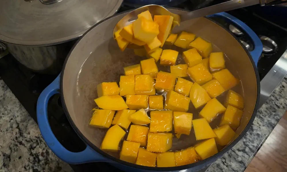 Pumpkin cubes being blanched in a pot of boiling water.