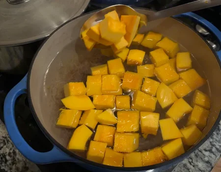 Pumpkin cubes being blanched in a pot of boiling water.