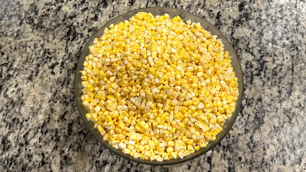 Corn kernels sitting in a glass bowl on the counter.