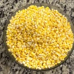 Corn kernels sitting in a glass bowl on the counter.