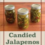 The image shows three mason jars filled with candied jalapenos on a wooden surface. The top part features a beige background with red text reading "Water Bath Canning." Below the jars, the text "Candied Jalapenos" is prominently displayed in green. At the bottom center, there is a small jar icon with a leaf design.