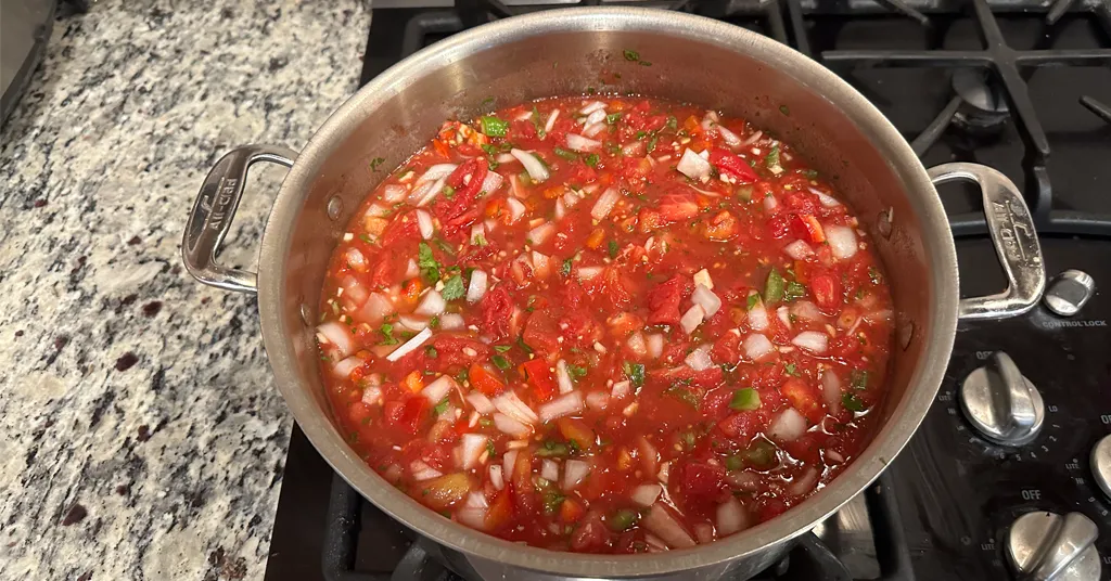 Stainless Steel pot of fresh vegetable salsa being cooked on the stove.