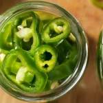 Pickled Hatch Peppers rings in a mason jar prepared to be pickled for canning.