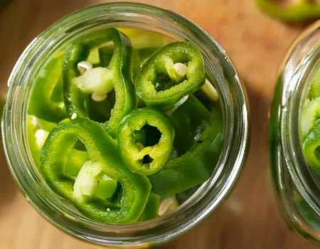 Pickled Hatch Peppers rings in a mason jar prepared to be pickled for canning.