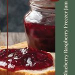 Close-up of a jar of blueberry raspberry freezer jam beside a slice of bread spread with vibrant red jam. The right side of the image features a green banner with vertical text reading 'Blueberry Raspberry Freezer Jam' and a circular badge labeled 'Tips & Tricks' in the upper corner. A decorative jar icon is positioned at the bottom of the banner.