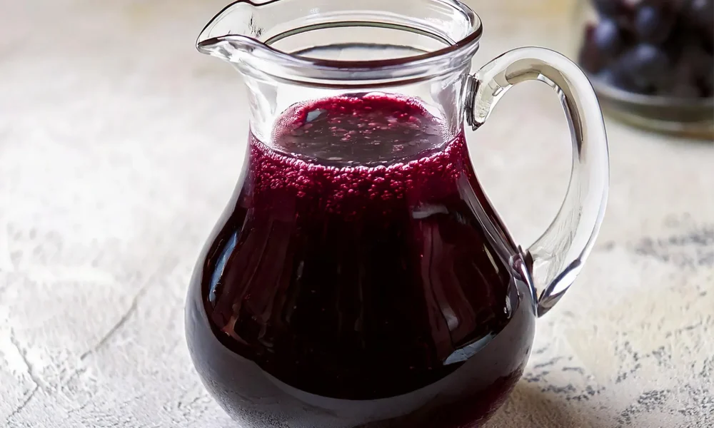 Blueberry Syrup in a glass pitcher.