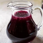 Blueberry Syrup in a glass pitcher.