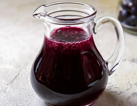 Blueberry Syrup in a glass pitcher.