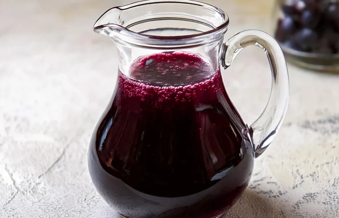 Blueberry Syrup in a glass pitcher.