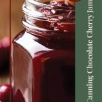 This image highlights a close-up of an open jar of chocolate cherry jam, showcasing its rich, dark hue and visible cherry chunks. A vertical green sidebar on the right contains the text "Canning Chocolate Cherry Jam" in an elegant font, while a circular label at the top reads "Tips & Tricks." A small jar logo at the bottom adds a touch of charm, complementing the overall rustic and homemade aesthetic.